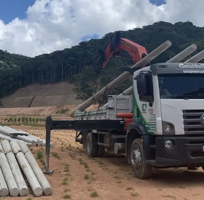 Caminhão guindauto da Easy Power descarregando postes de concreto em condomínio na Região Serrana